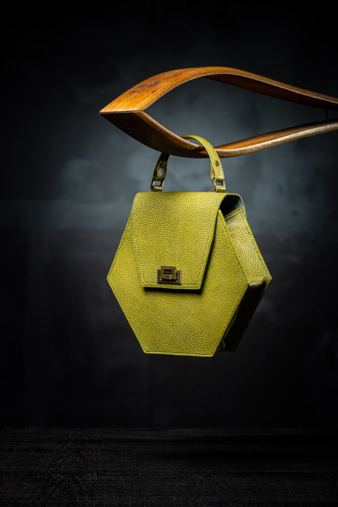 Victoria Baker's workbench with clamps, burnishers, thread and beeswax over dark leather hides